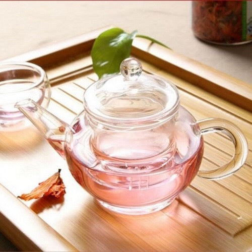 Petite théière Infusion Transparente sur un plateau de bois avec tasse
