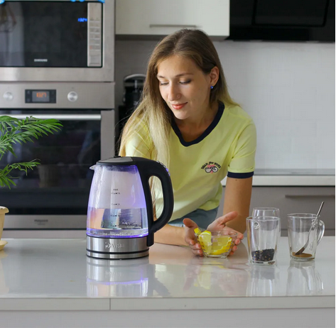 Bouilloire électrique RapidGlass sur comptoir avec femme et tasses