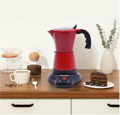 Cafetière italienne electrique Roma Moka sur comptoir avec tasse cafe et gateau