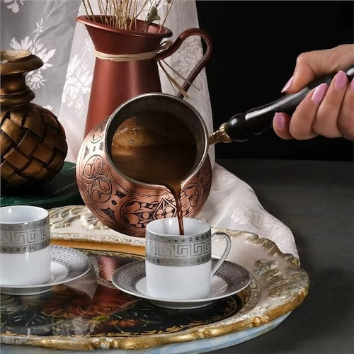 Cafetière truque Cuivre Artisanal verse café dans tasse sur un plateau