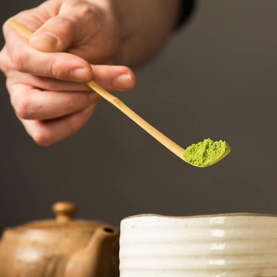 Cuillère à thé matcha au dessus bol blanc