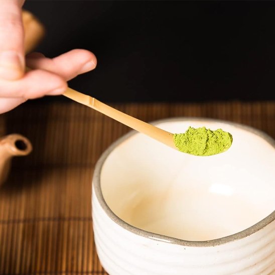 Cuillère à thé matcha sur bol blanc