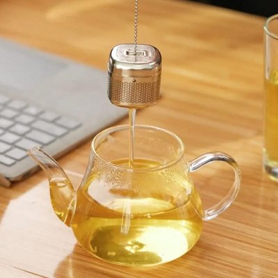 Infuseur thé Éco Saveurs coule dans théière sur bureau