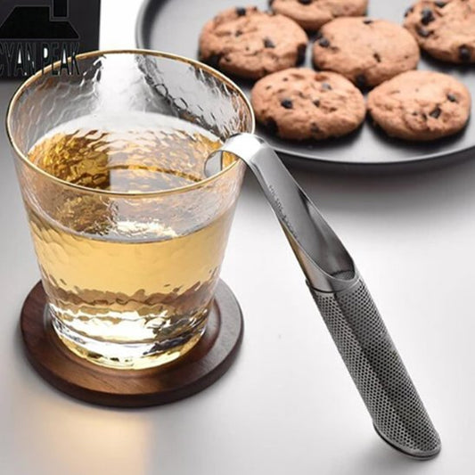 Infuseur thé Infusion Parfaite appuyé sur verre de thé et cookies