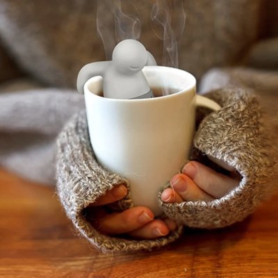 Main de femme tient tasse avec infuseur à thé 