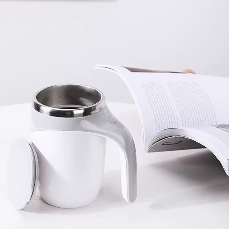 Mug Mélangeur Automatique blanc sur table avec livre