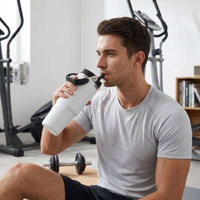 Mug isotherme ThermoPratique homme boit assis au gym 