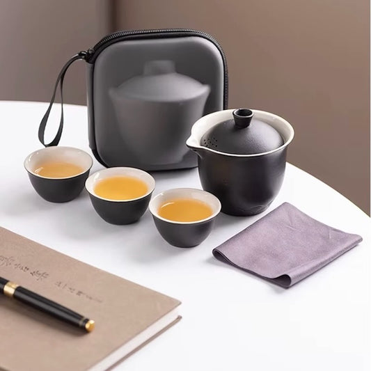 Service a the TravelTeaSet sur table avec livre et stylo