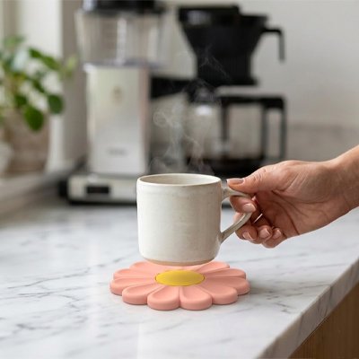 Sous verre​ Marguerite personne tient tasse au dessus du sous verre