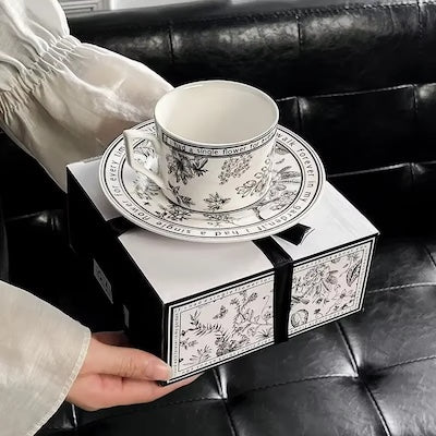 Tasse à café Summer Lily sur sa boîte tenue par une femme 