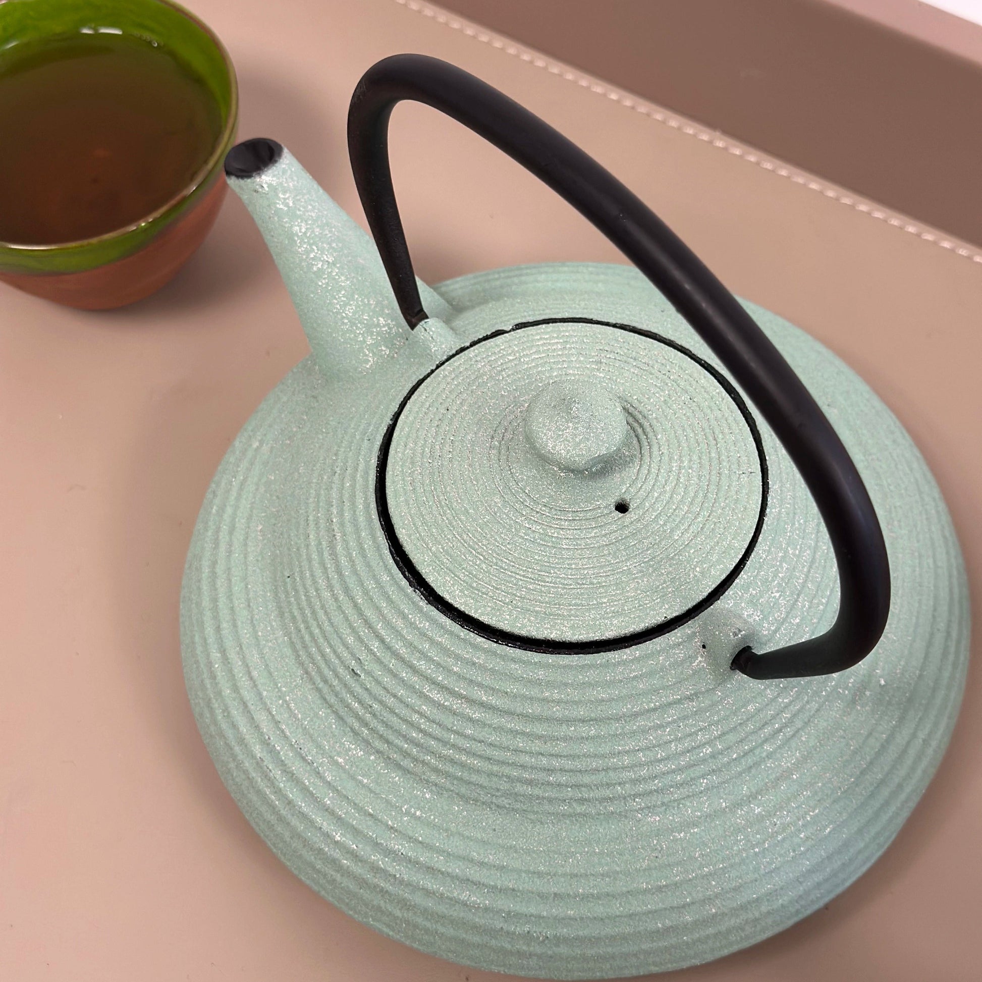 Theiere en fonte Japonaise 750ml sur table avec tasse de  thé